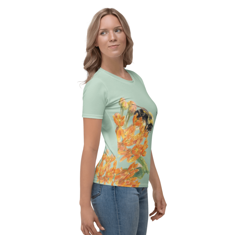  Right veiw Woman wearing a light green t-shirt with a colorful graphic design of a bee and flower