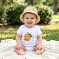 Baby sitting on a blanket wearing a White 100% cotton baby one-piece featuring the bumblebee design from the Golden Dust collection.