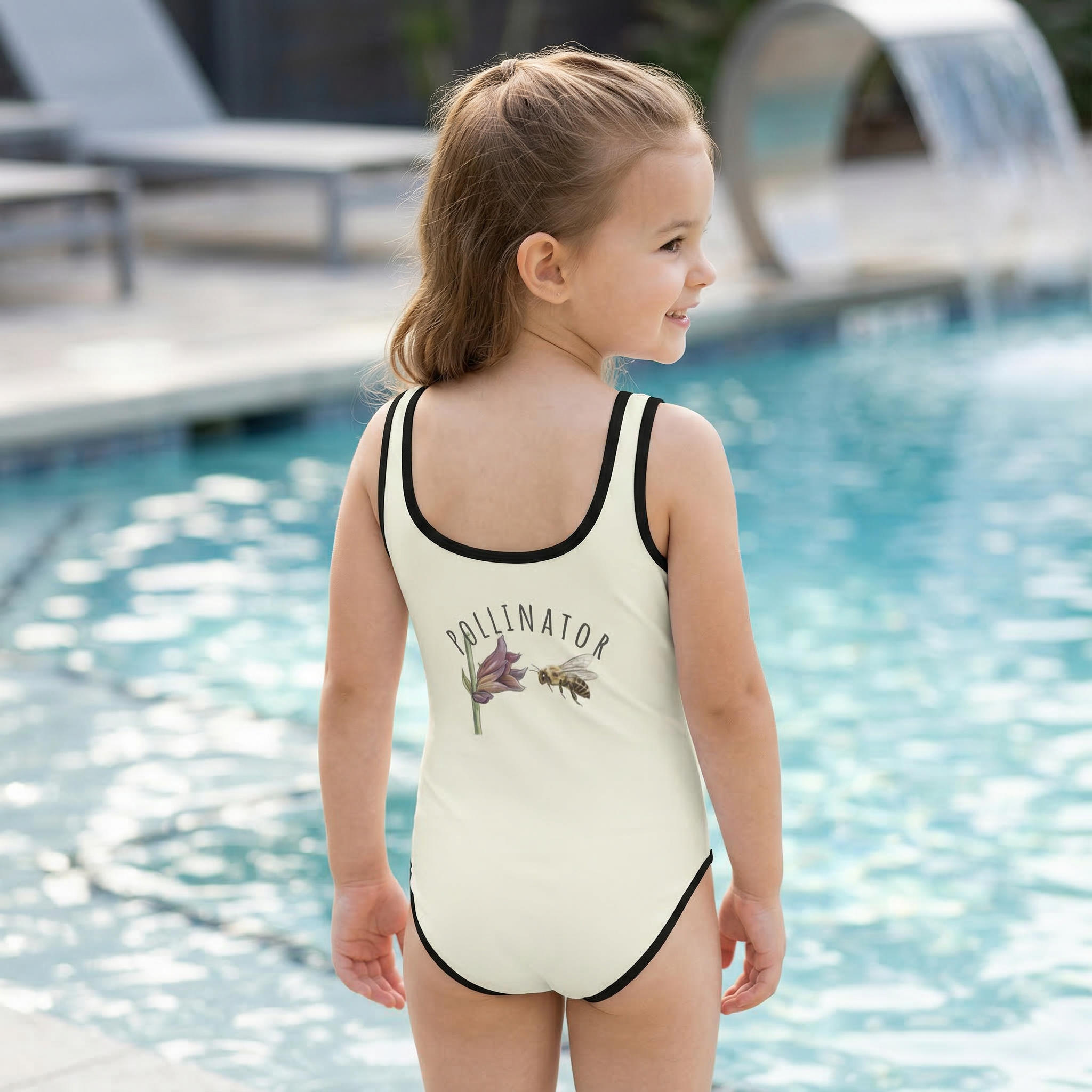 Back view of a "Toddler girl wearing Meadow Whisper: Golden Dust kids Swimsuit standing by a swimming pool."