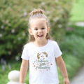 Child wearing a white t-shirt with 'Nature's Little Pollinators' text and hummingbird graphics outdoors.