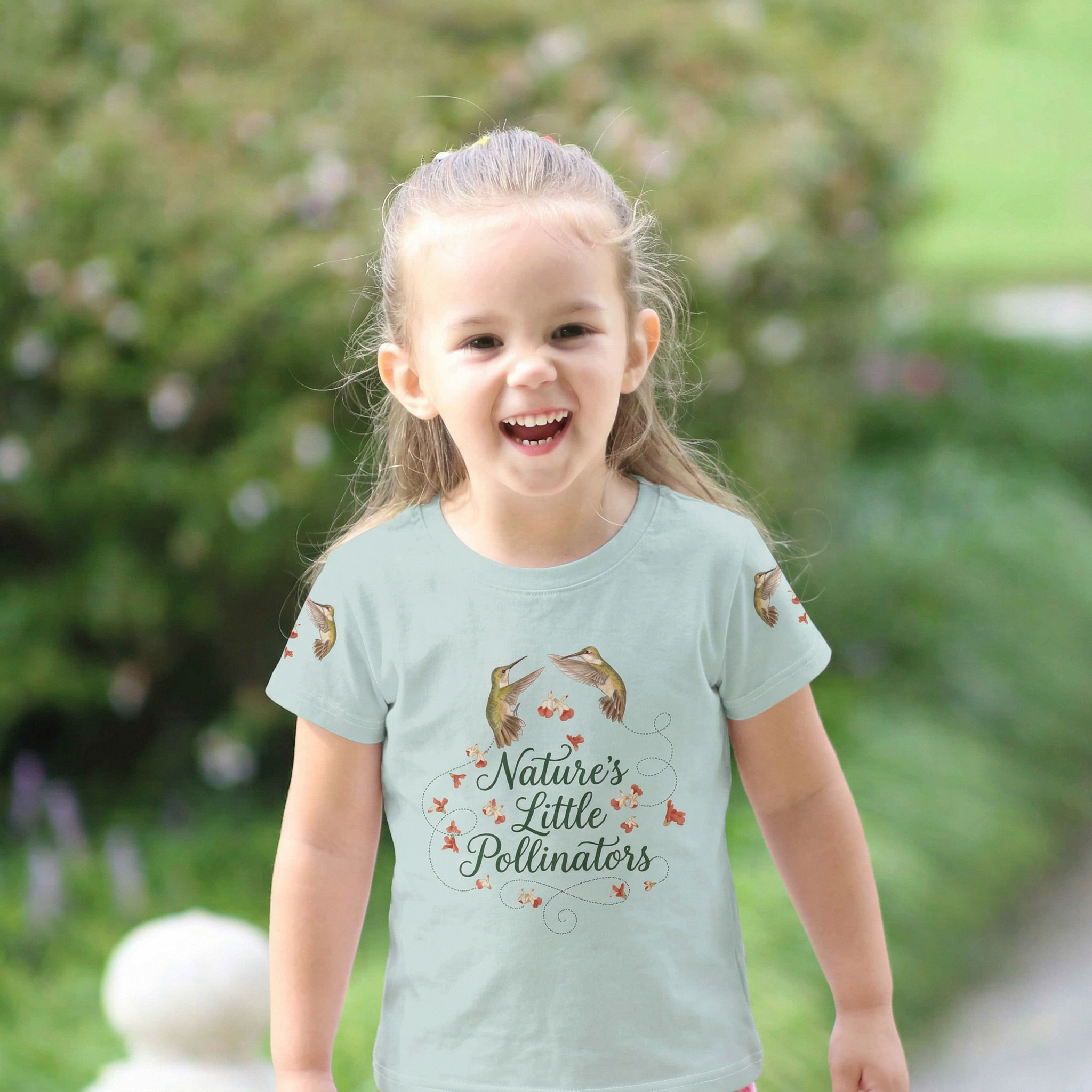 Child wearing a 'Nature's Little Pollinators' t-shirt outdoors Tinywing Tales