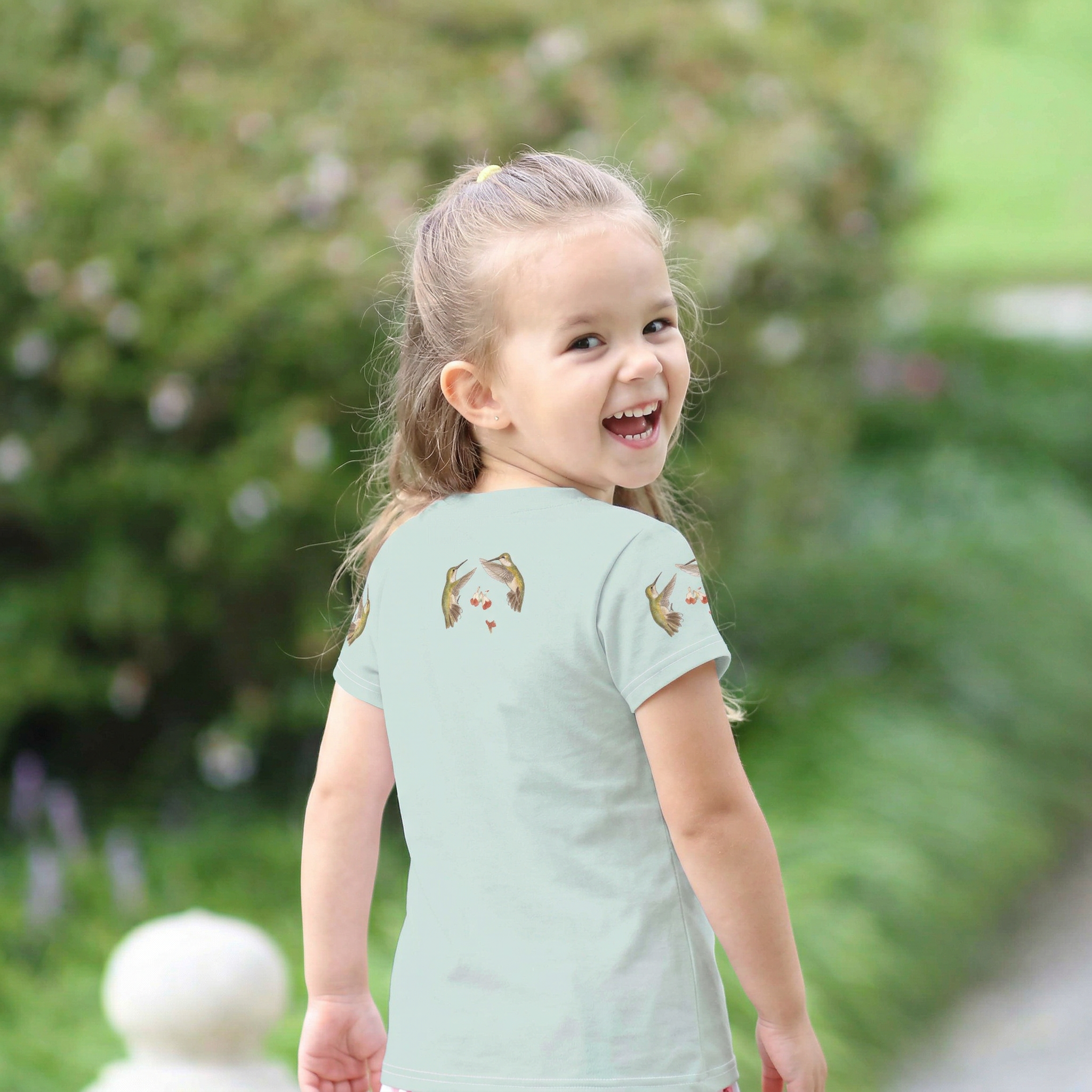 Back view of Child wearing a 'Nature's Little Pollinators' t-shirt outdoors Tinywing Tales