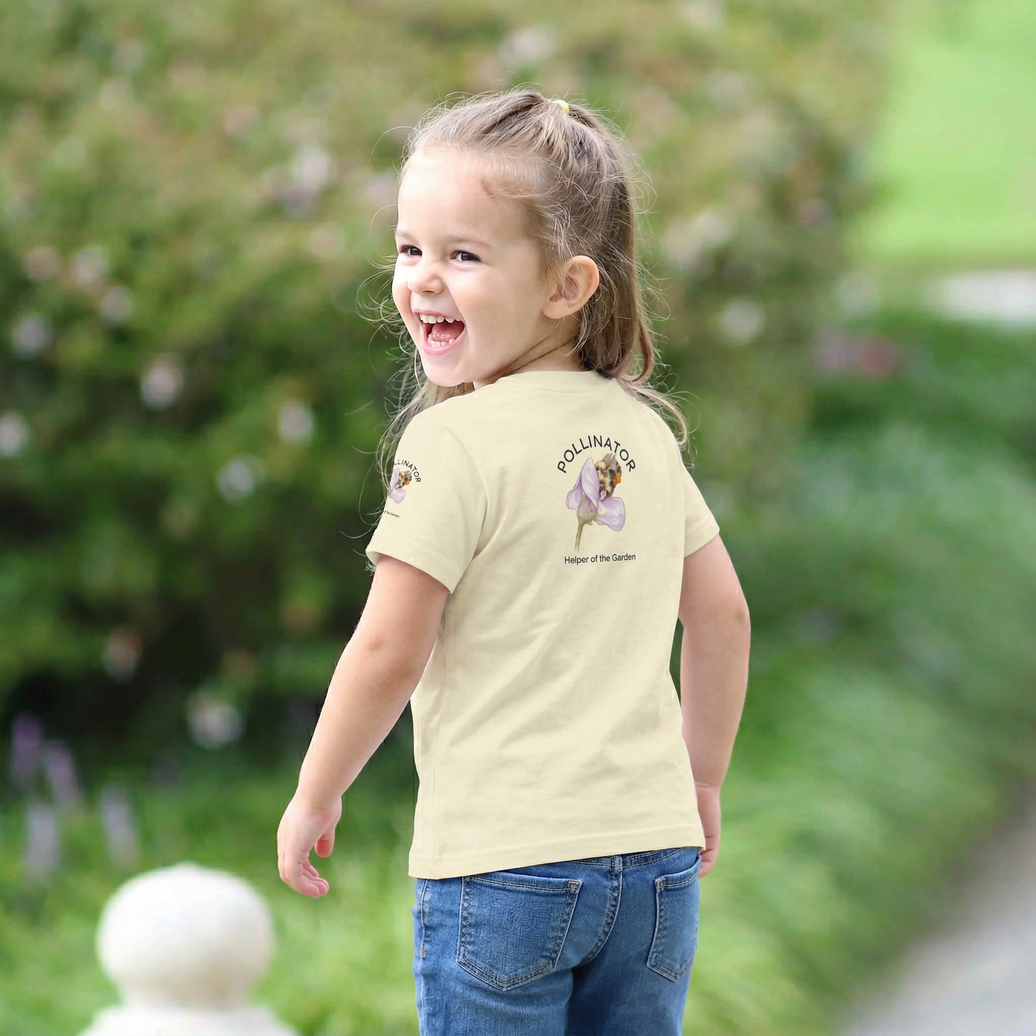 Back view of Child wearing a t-shirt with a graphic of a bee and text, standing outdoors. Tinywing Tales