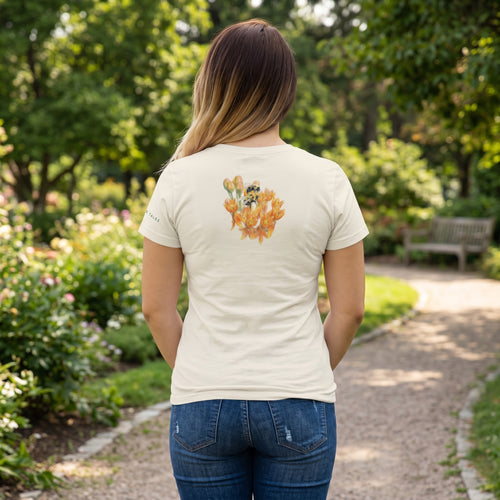 Back View of Woman wearing a beige t-shirt with a bee and flower design in a park
