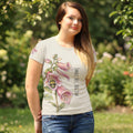 Woman wearing a t-shirt with floral design with bee and text in a garden setting