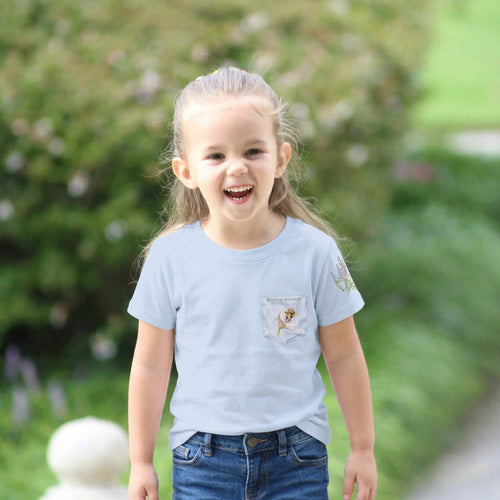 Child wearing a light blue t-shirt with a small design bee and flower on a blurred green outdoor background