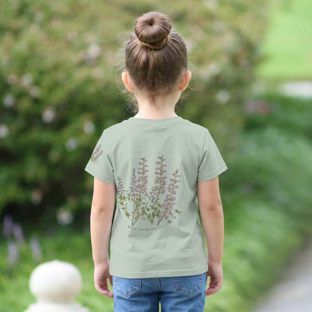 Backview of a Child wearing a light sage t-shirt with a small design on a faux pocket design of a bee and flower. Text "Bloom Bound" Tinywing Tales