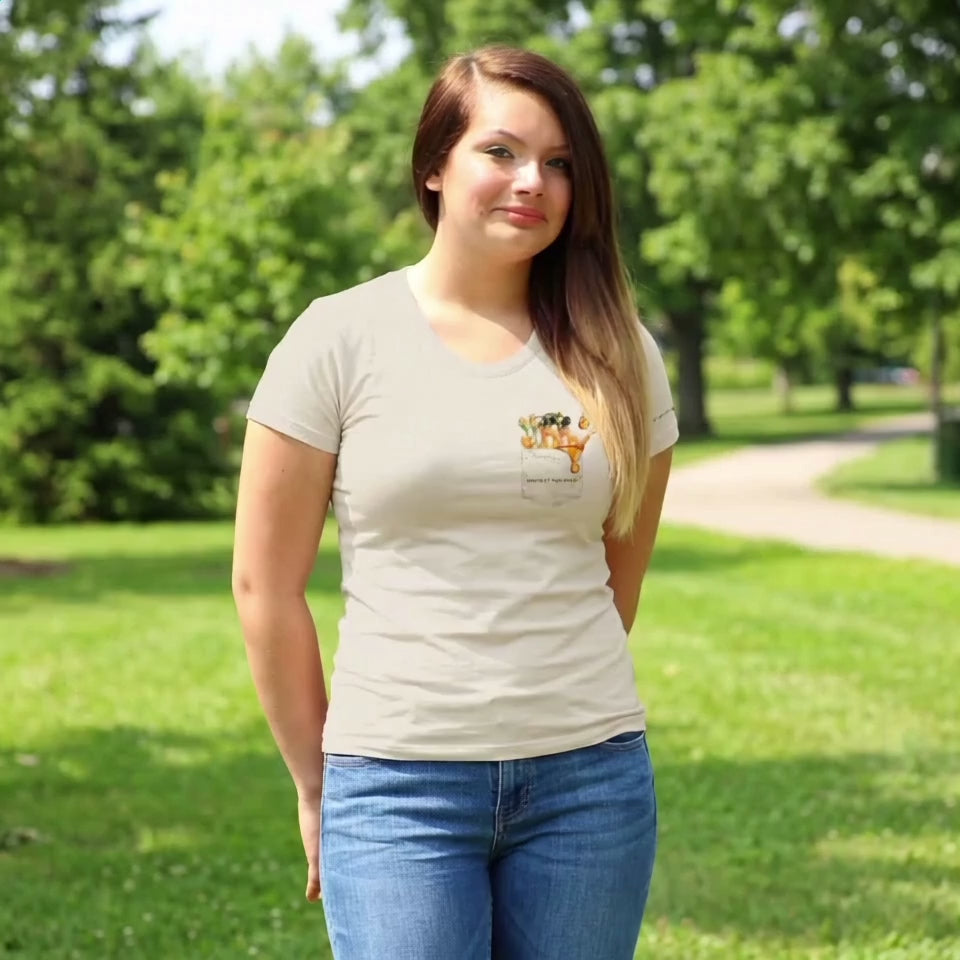 Video of Woman wearing a beige t-shirt with a bee and flower design walking in a park