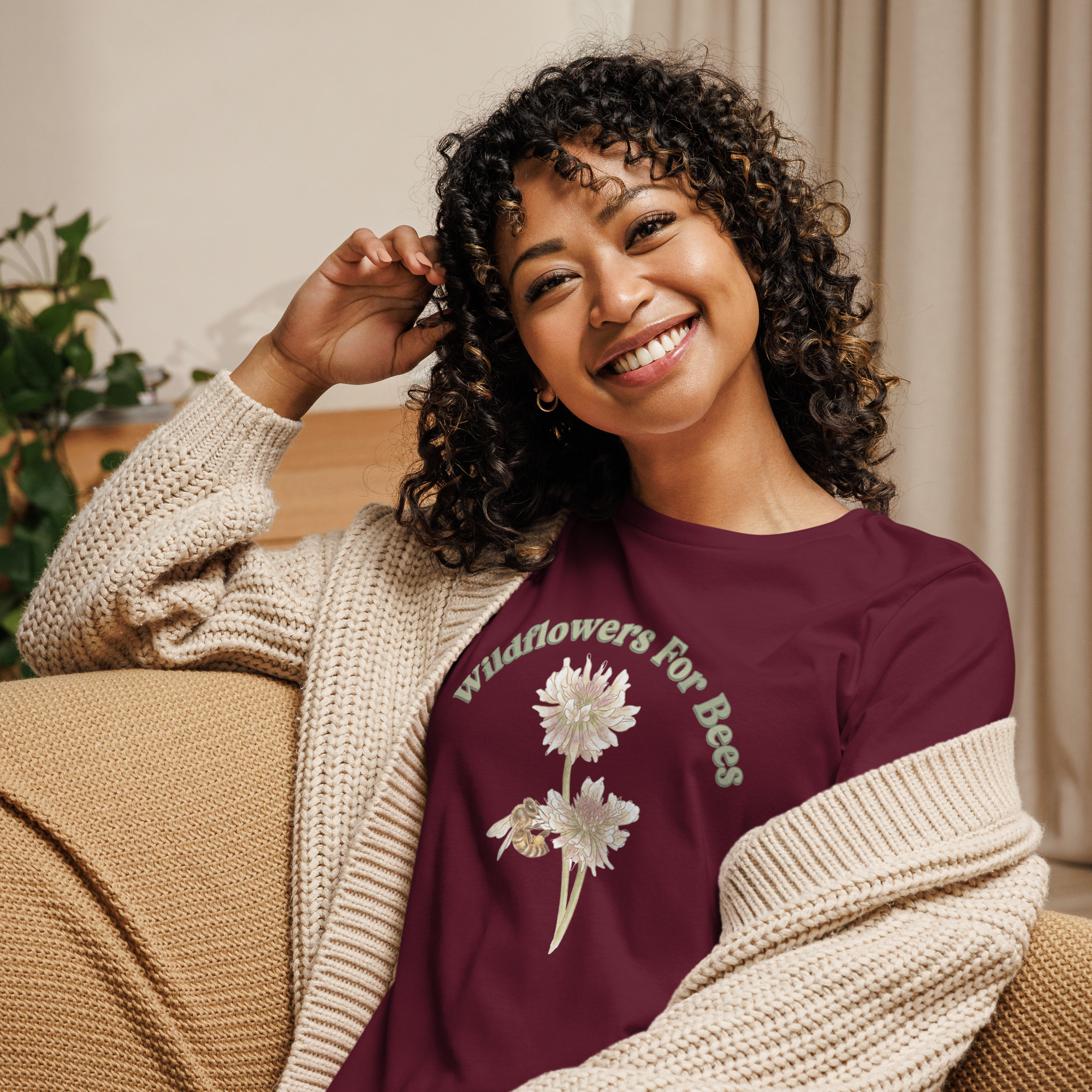 Woman wearing a maroon T-shirt with floral and bee design and text, "wildflowers for bees