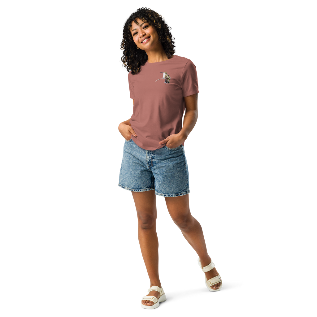 Woman wearing mauve tee shirt with photo of a hummingbird on a branch and jean shorts