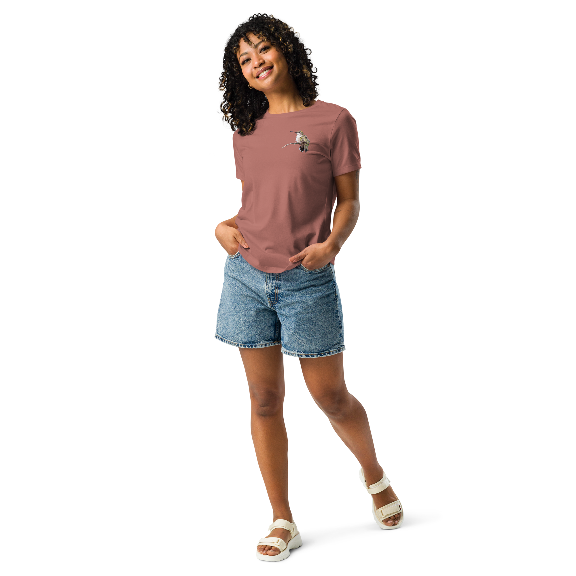 Woman wearing mauve tee shirt with photo of a hummingbird on a branch and jean shorts