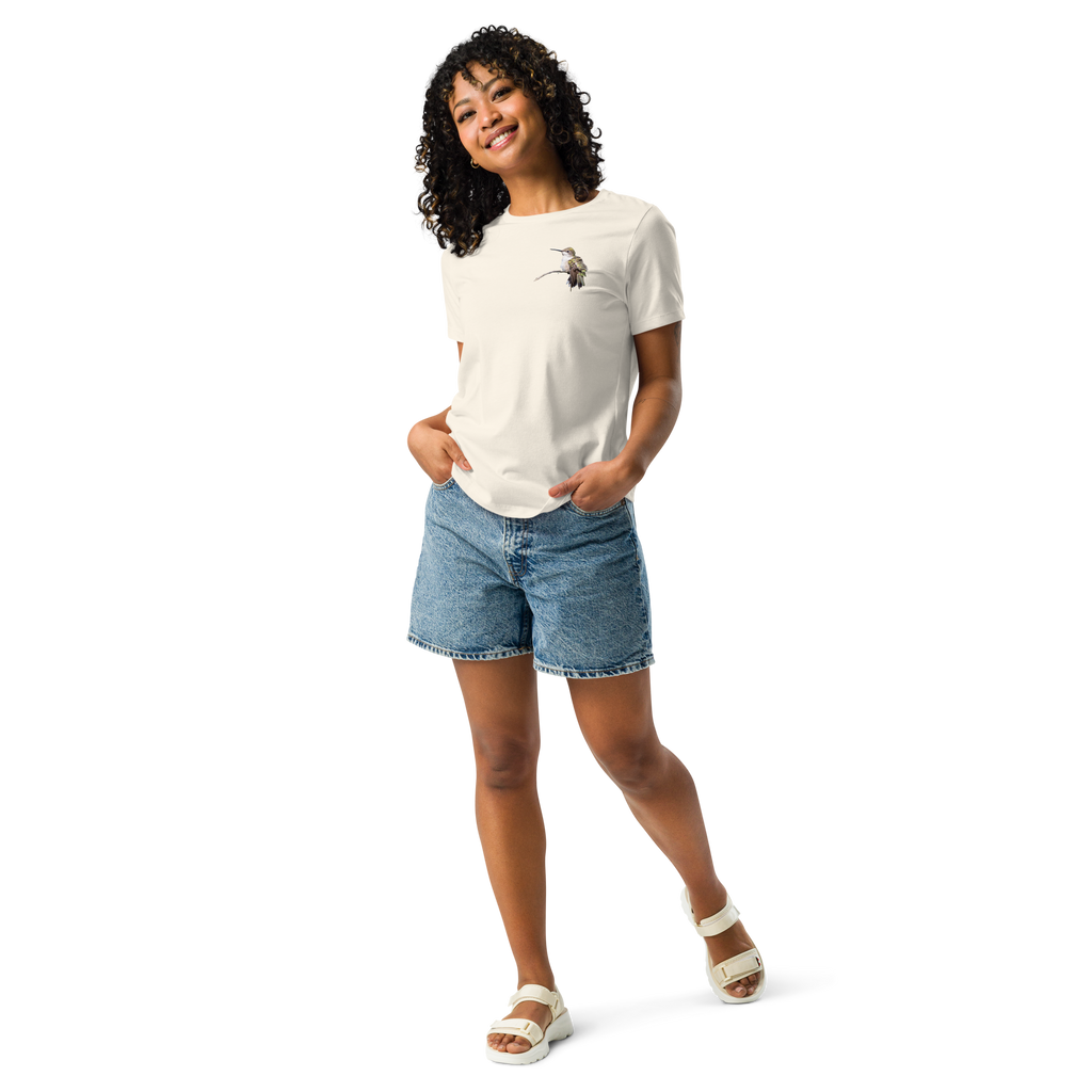 Woman wearing natural color tee shirt with photo of a hummingbird on a branch and jean shorts